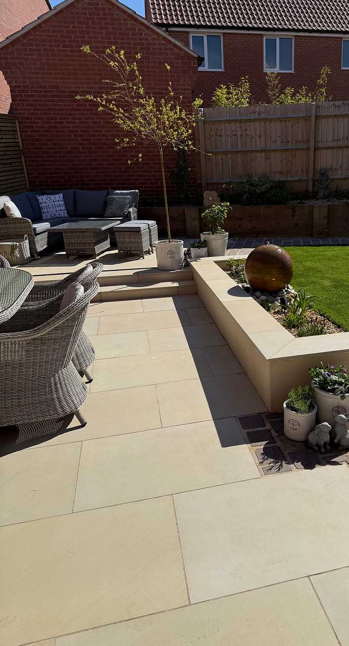 Professionally installed porcelain patio with raised seating and elegant design