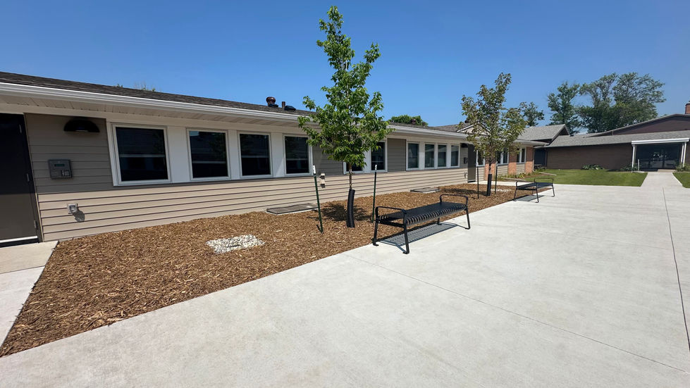 Concrete patio with bench seating and wood mulch planting beds.