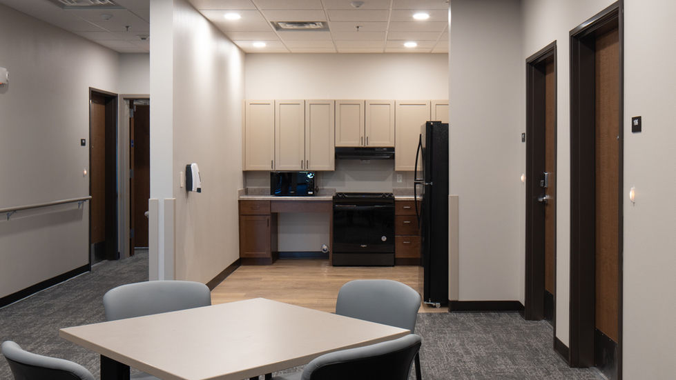 Community kitchenette outside of a lounge and adjacent apartment units.