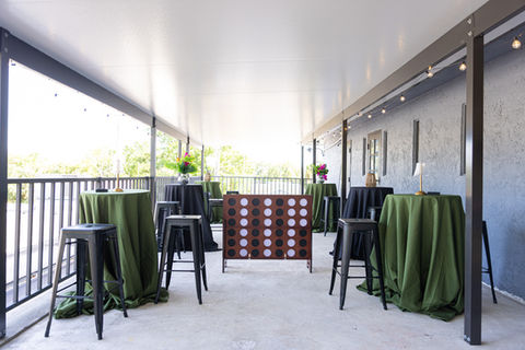 A large connect four game and cocktail tables on the upstairs balcony. Photo by Ideal Shots LLC.