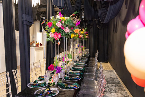 Black dinning setup with tropical flower centerpieces