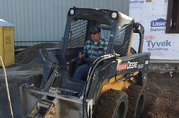 man on tractor digging up dirt