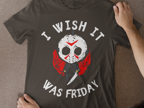 A man holding a dark charcoal Friday the 13th Shirt with a cute Jason Voorhees parody design and "I Wish It Was Friday" text.