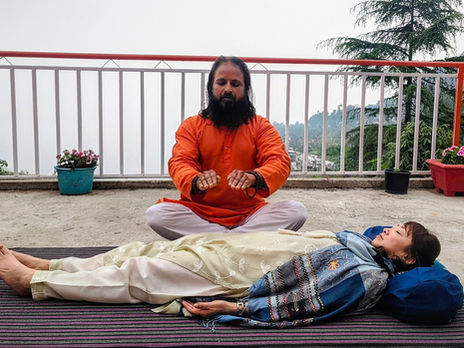 Reiki healing students channeling positive energy during a holistic wellness training session at Om Yoga Ashram with scenic Himalayan views in the background.