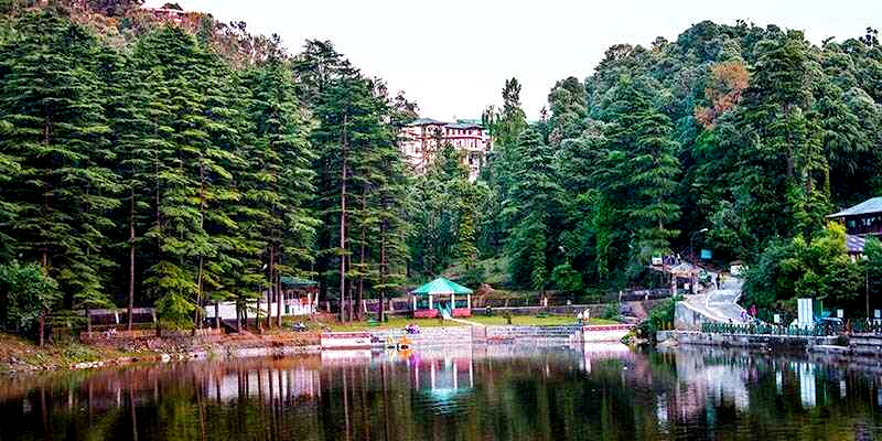 Yoga students practicing asanas outdoors with a view of the Himalayan mountains at sunrise.