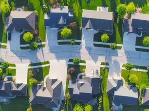 Aerial view of a suburban neighborhood with neatly arranged houses and green lawns. Curved streets and scattered trees. Construction. Real Estate. HFM logo