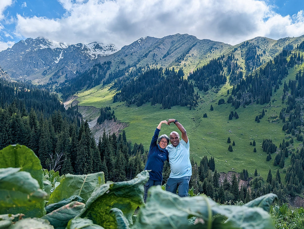 Kamakino Travel - Couple making a heart shape in the lush Medeu mountain valley near Almaty, Kazakhstan.