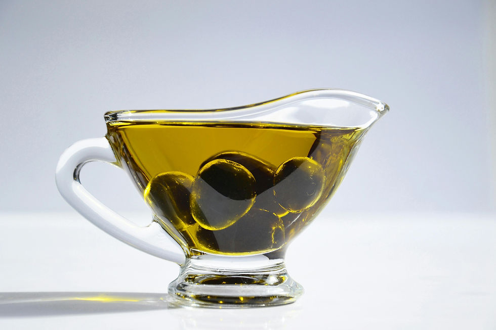 A glass mug filled with olive oil and olives