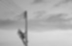 Man in safety harness climbs electricity pylon.