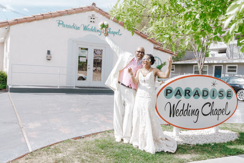 Newlyweds posing with joy at Paradise Wedding Chapel sign; ceremony backdrop TIMELESS CONNECTION