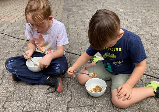Kinder sitzen vor ihrem keltischen Eintopf und probieren ihn.