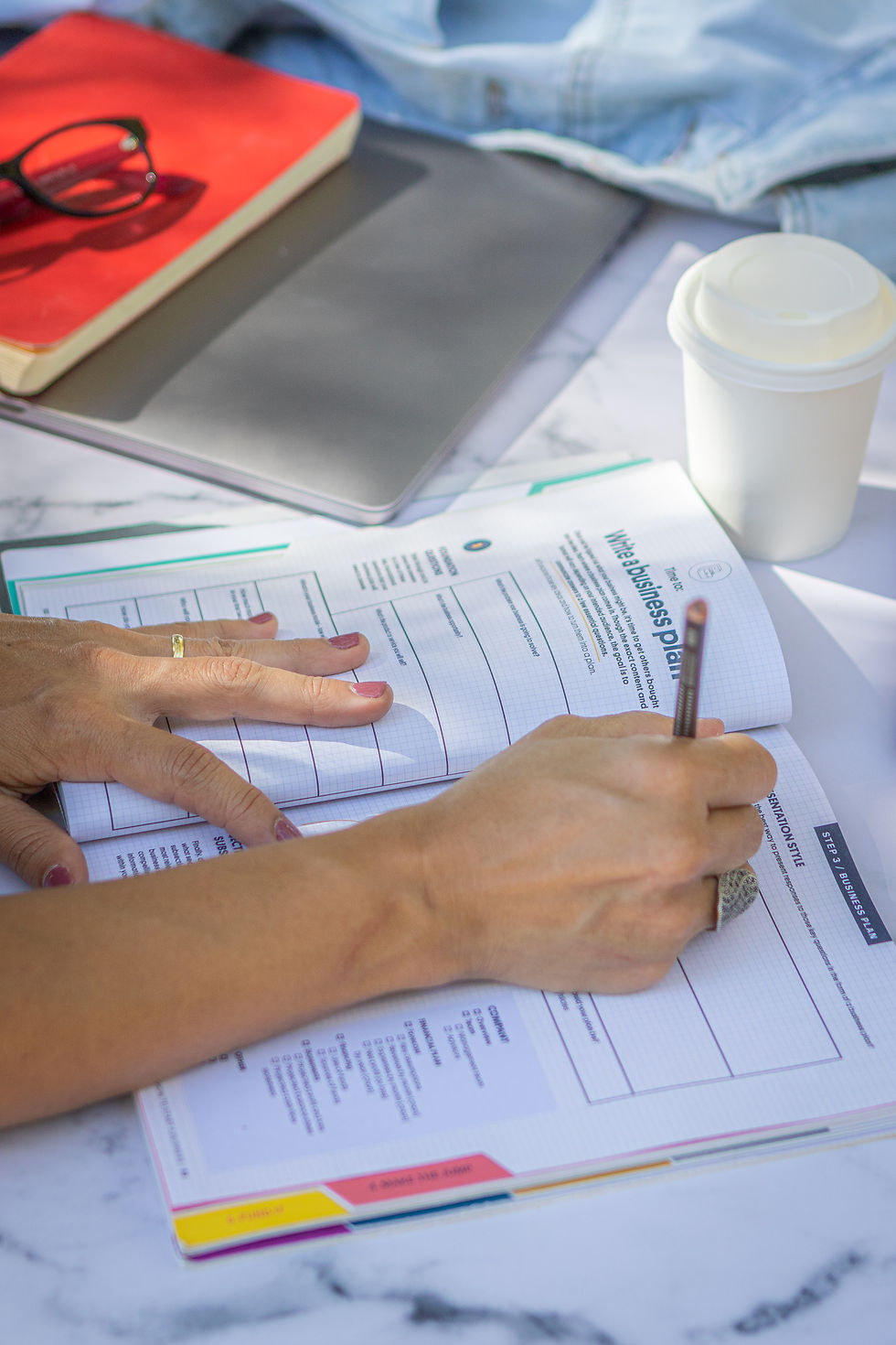 maos de mulher escrevendo um business plan