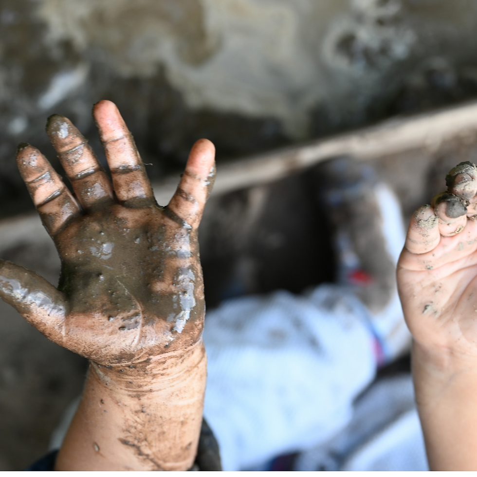 child's muddy hands