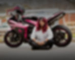 Woman sitting in front of pink motorcycle