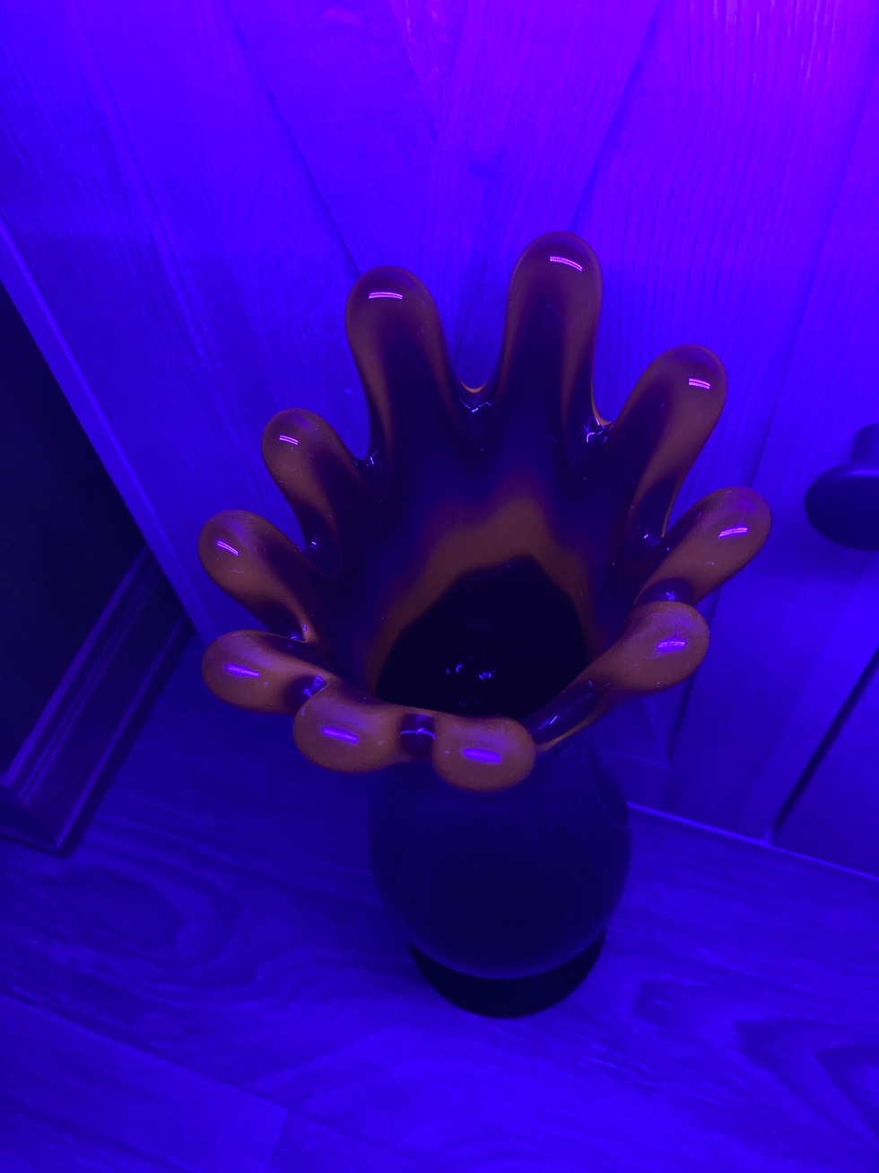 Thumbnail: Vintage LE Smith amberina swung vase in deep red glass, displayed on a glass shelf in a boutique setting. The vase has a flared base and a tall, narrow neck with a smooth swung top.