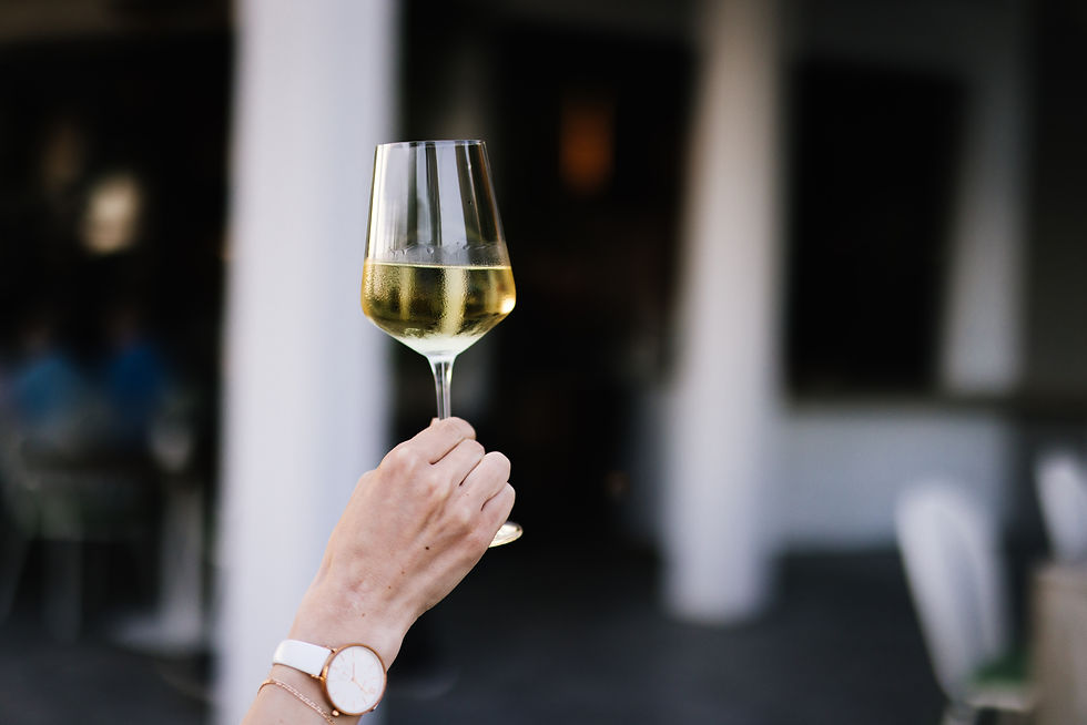 woman holding white wine glass