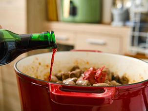 red wine being poured into food