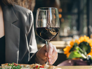 a woman holding wine glass by stem