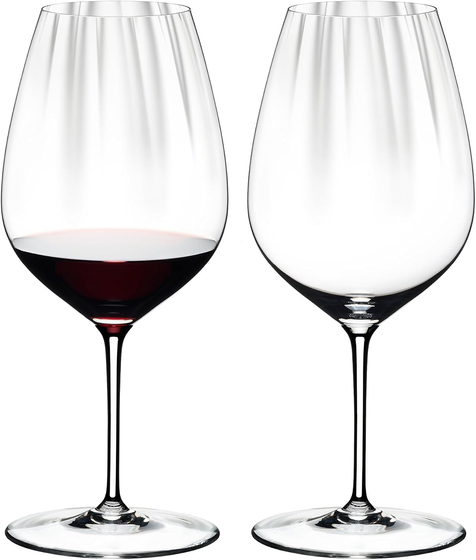 Two tall wine glasses on white background, one partially filled with red wine and the other empty.