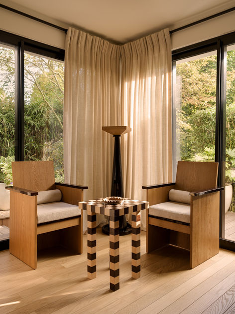 Salon de la maison Bagatelle à Neuilly-sur-Seine, deux fauteuils en chêne devant les fenêtres