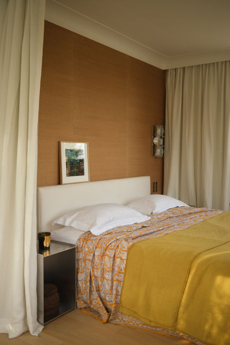 Chambre parentale dans l'ancienne véranda, murs de sisal et couverture jaune