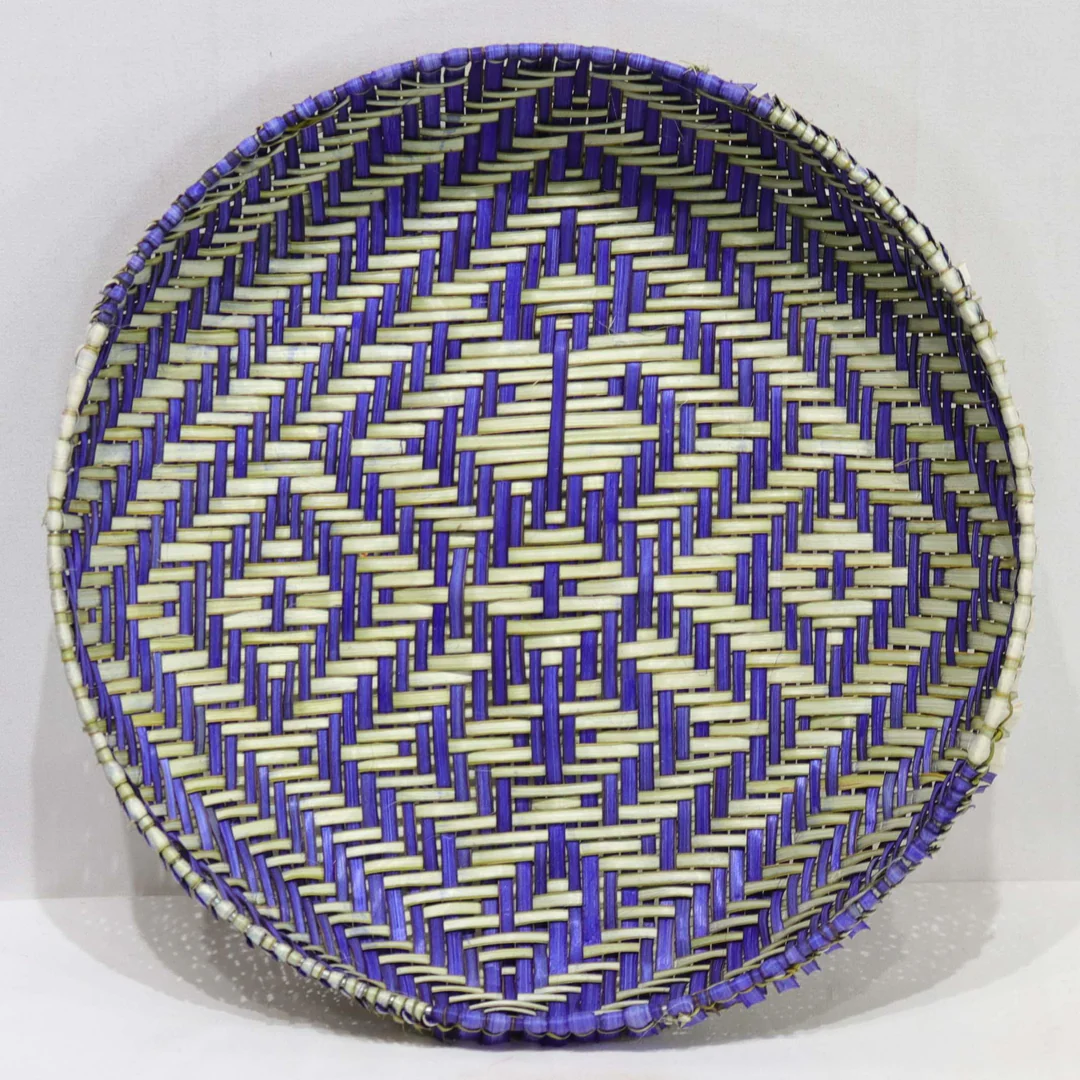 "Un magnifique panier à tamis Hopi, tissé à la main, révèle un motif délicat inspiré de Spider Woman. Cette pièce artisanale est confectionnée avec du yucca, utilisant les teintures naturelles du yucca et l'indigo provenant des plantes cultivées par la talentueuse Dorleen Gashweseoma. Une fusion de tradition et de créativité, capturant l'essence de l'art Hopi et de la mythologie de Spider Woman