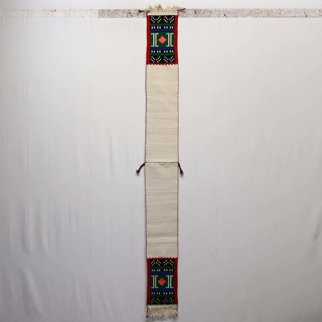 Écharpe cérémonielle Hopi tissée à la main en coton (blanc) et laine (colorée). Portée lors des danses Kachina, les motifs aux extrémités représentent nuages et pluie, symbolisant la connexion sacrée avec la nature." 
