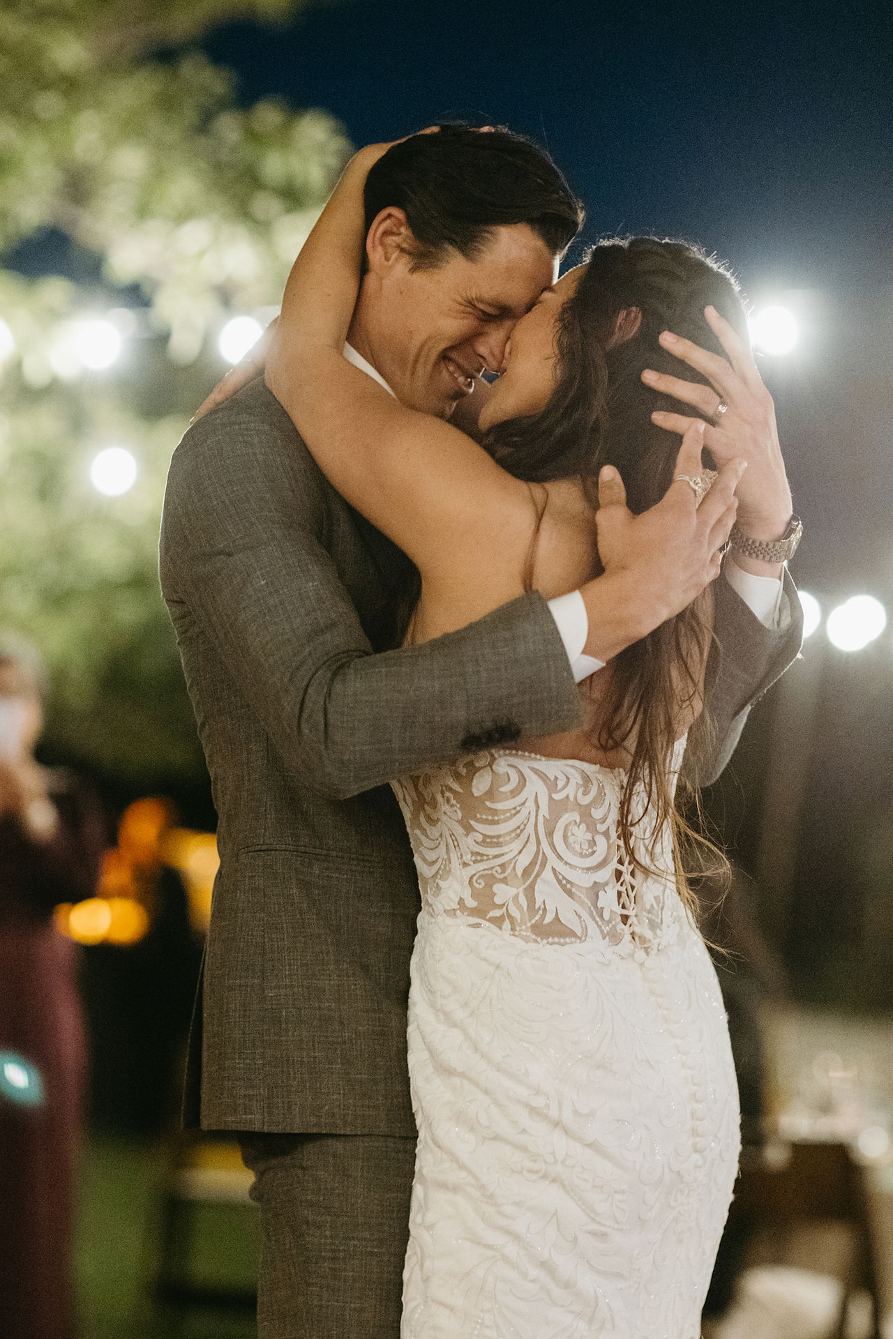 bride and groom dancing under twinkling lights