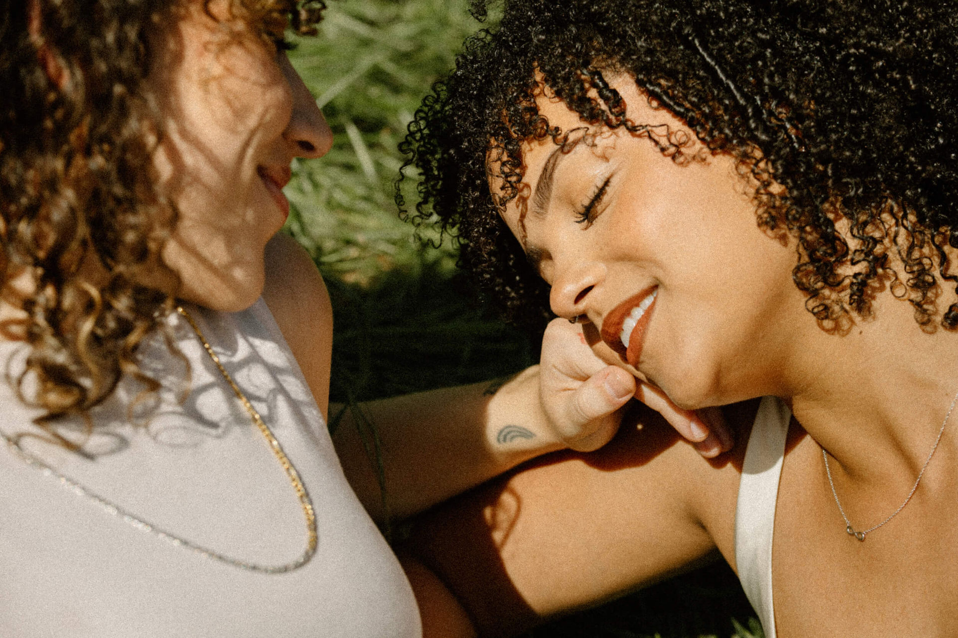 Lesbian engagement session couple embracing in field in Los Angeles