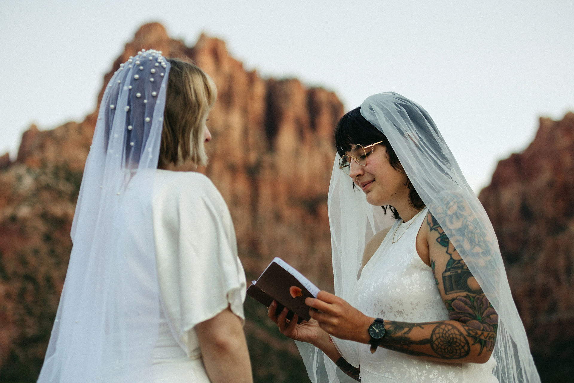 two brides exchanging vows during sunrise at zion national park elopement