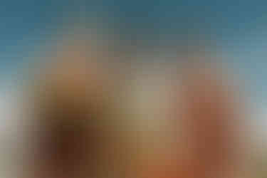 editorial photo of bridesmaids in desert wedding looking at camera. bridesmaids are wearing coral bridesmaids dresses. wedding is at sacred sands in joshua tree.