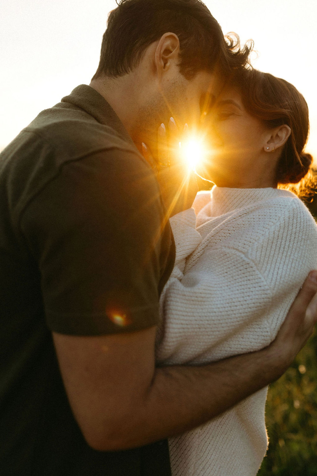 sunset engagement session intimate moment of couple with sun flare