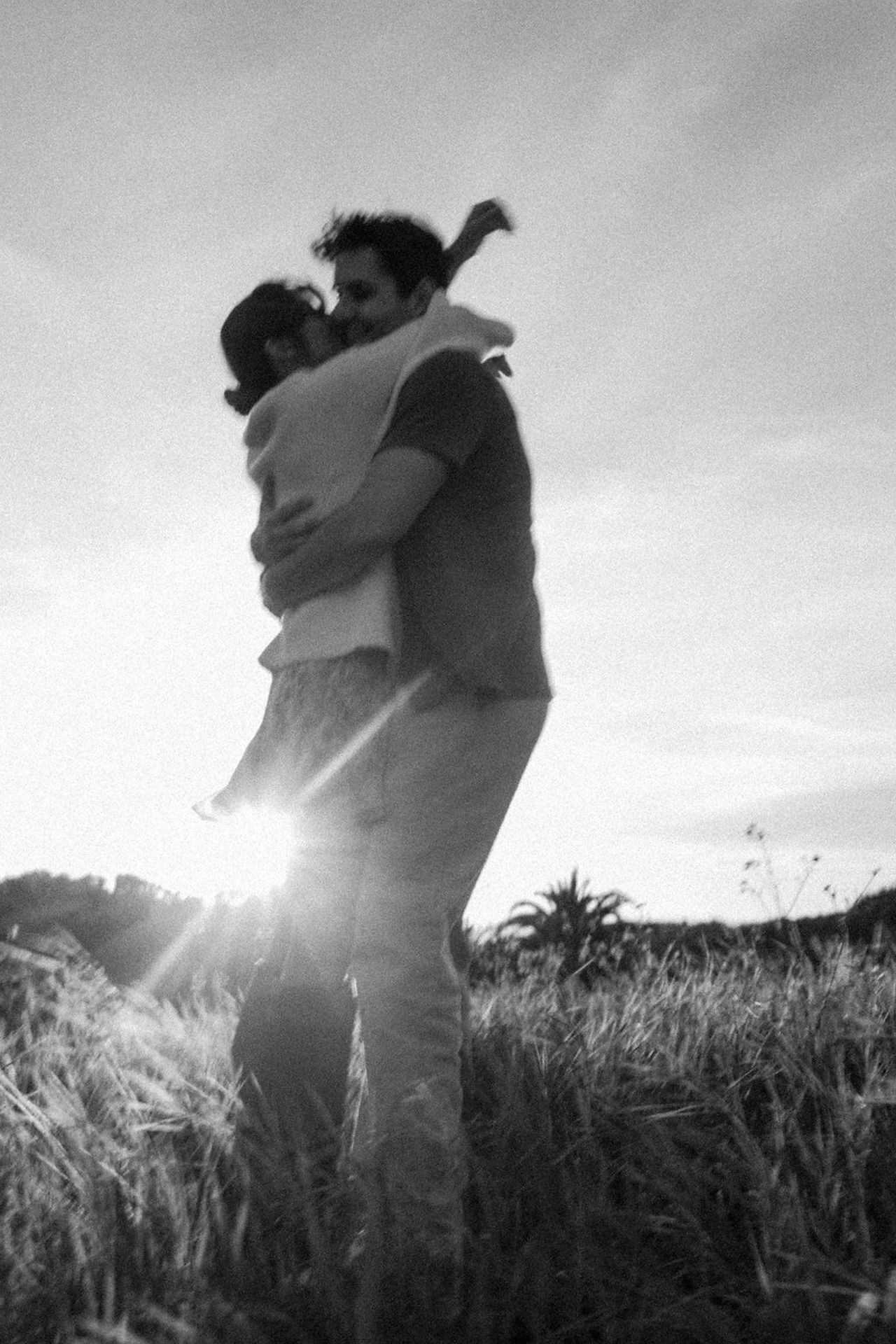 engagement photography girls arms around guys neck with sun flare