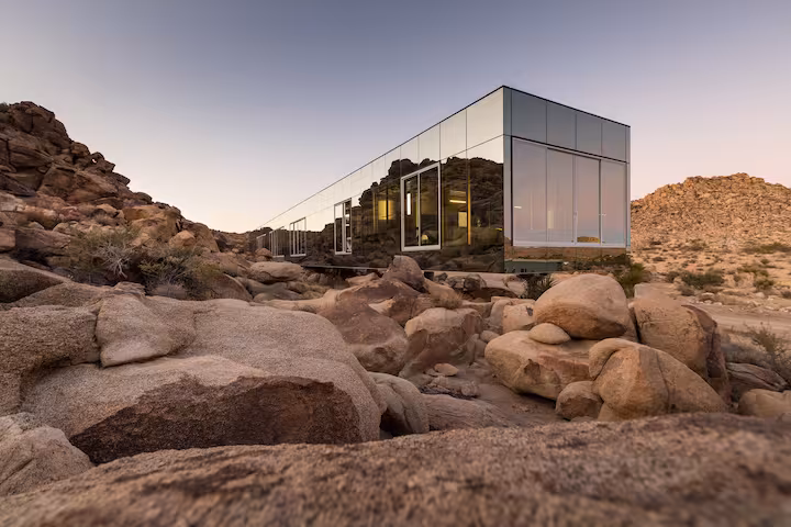 Invisible House wedding venue in Joshua Tree, featuring mirrored glass walls reflecting the desert landscape during blue hour
