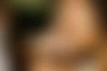 close up photo of girl's hand caressing her girlfriend's cheek in a field in los angeles