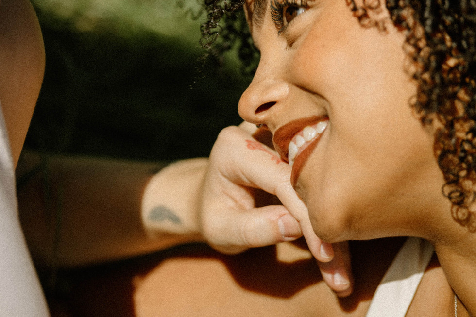 close up photo of girl's hand caressing her girlfriend's cheek in a field in los angeles