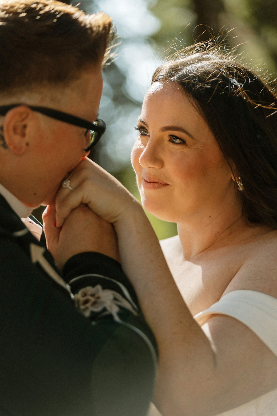 bride kissing bride's hand in redwood grove in orange county