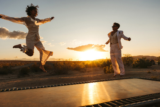 brides jumping on the trampoline during golden hour at nxwhere california captured by marissa kay photography joshua tree wedding photographer 