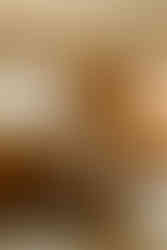 groom wearing suspenders and hat drinking whiskey in rocking chair