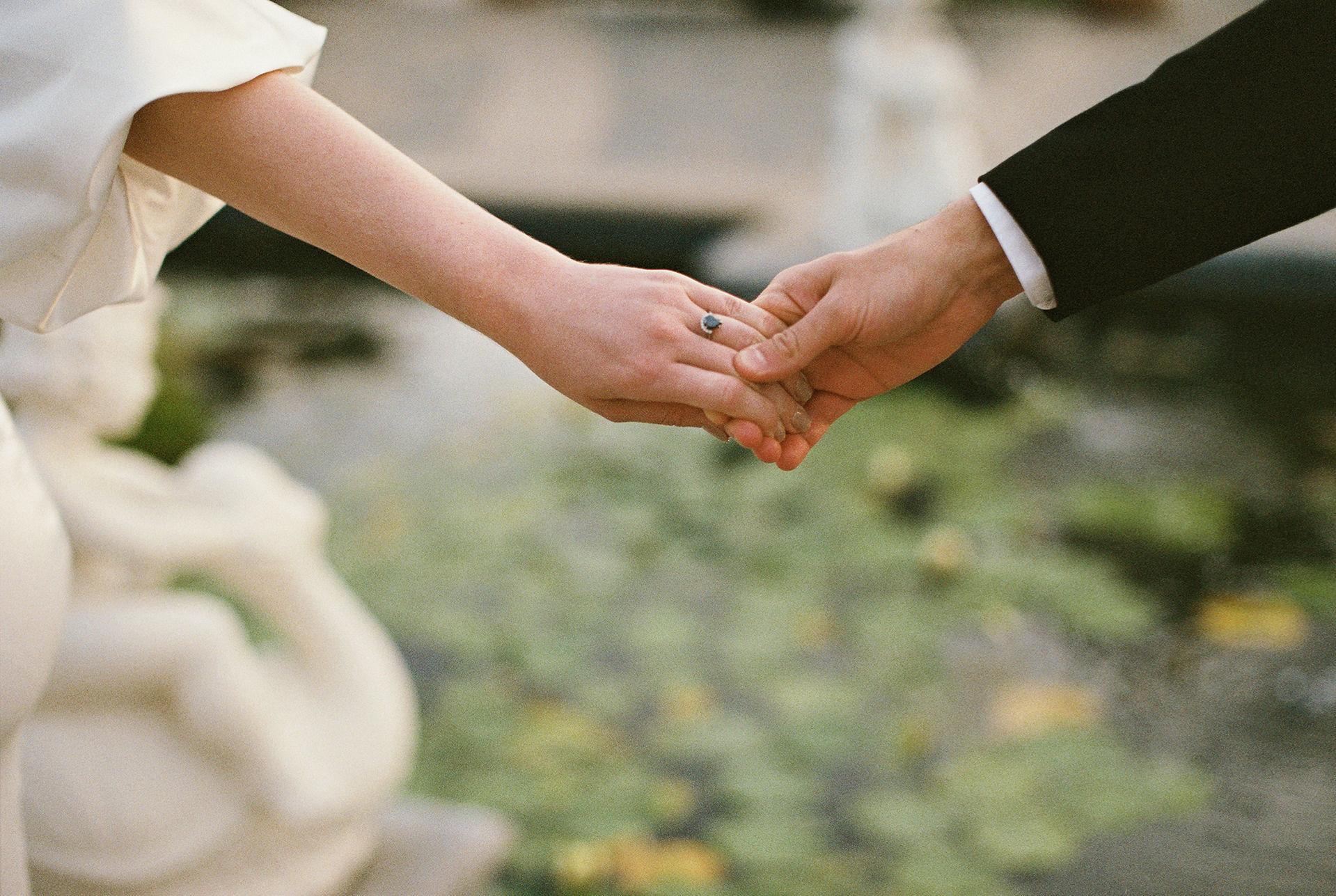 bride and groom holding hands in front of fountain in italy wedding
