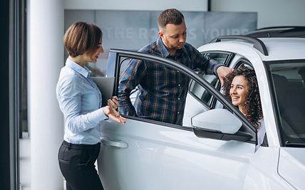young-couple-talking-sales-person-car-showroom.jpg