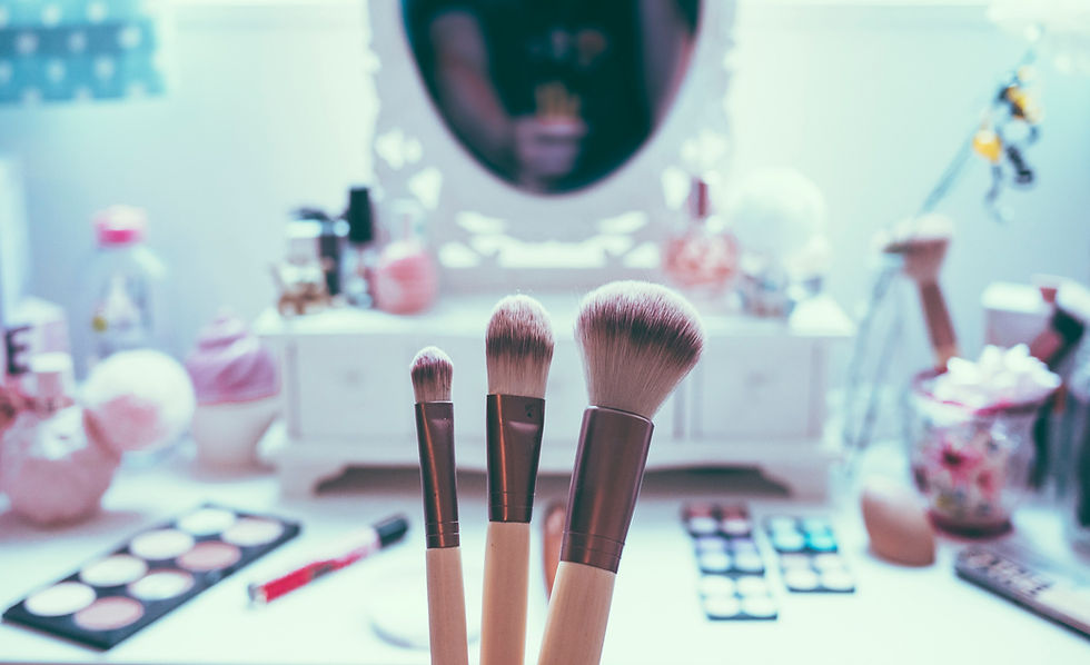 280331-woman-holding-up-three-makeup-brushes-in-front-of-.jpg