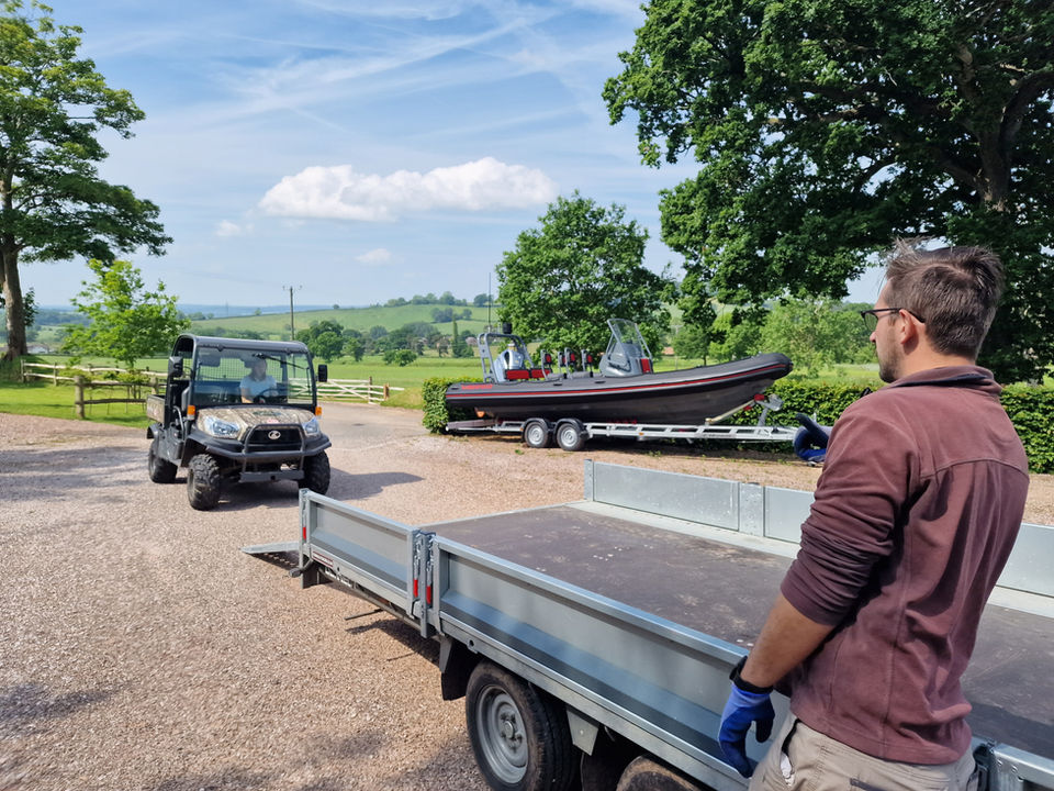 Someone guiding an ATV onto a trailer.