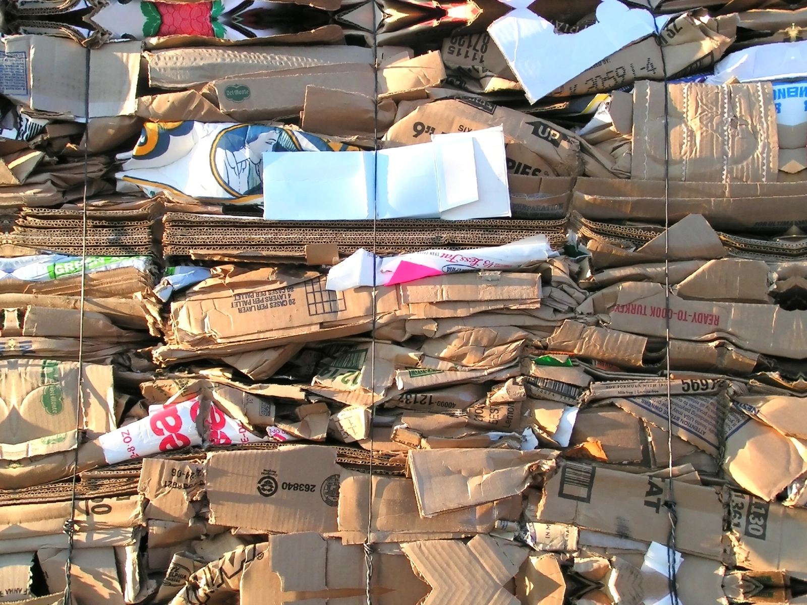 A stack of bundled cardboard boxes, displaying various colors and prints