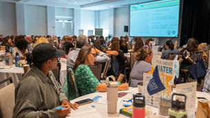A conference room full of Florida teachers attentively look up at a presentation at The Everglades Foundation's 8th Annual Everglades Teacher Symposium.