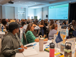A conference room full of Florida teachers attentively look up at a presentation at The Everglades Foundation's 8th Annual Everglades Teacher Symposium.
