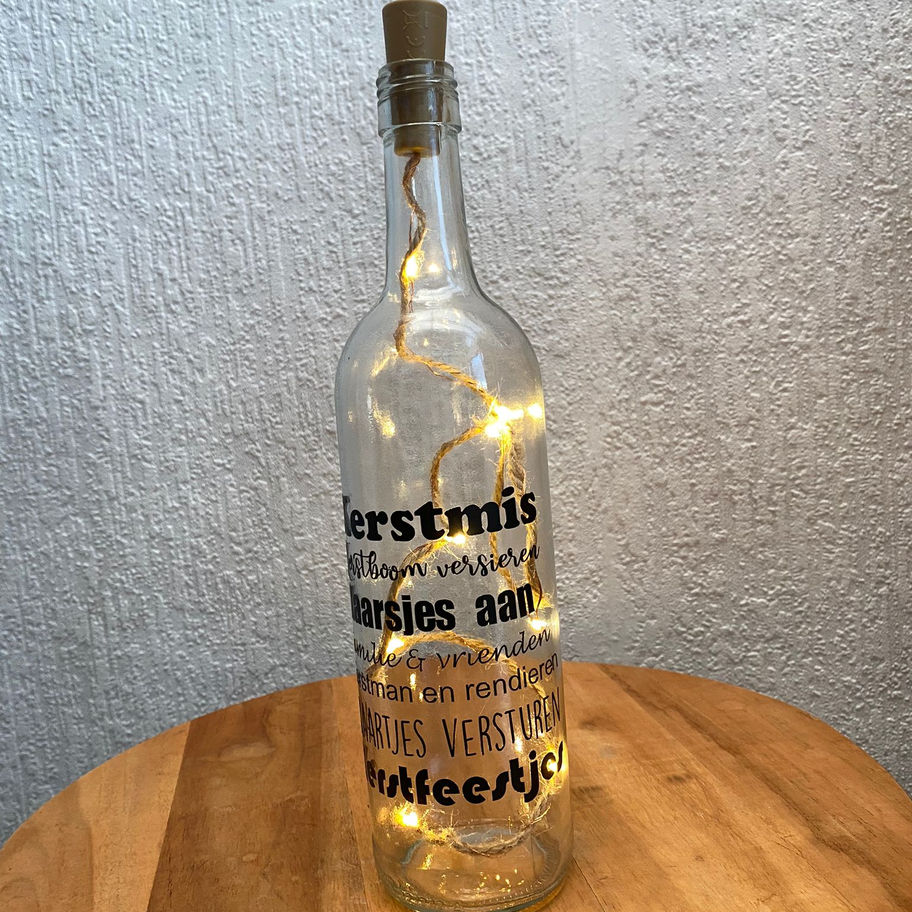 Sfeervolle kerstlichtfles met warm LED licht en sneeuwvlokken