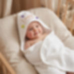 Baby met een gepersonaliseerde baby badcape met naam.