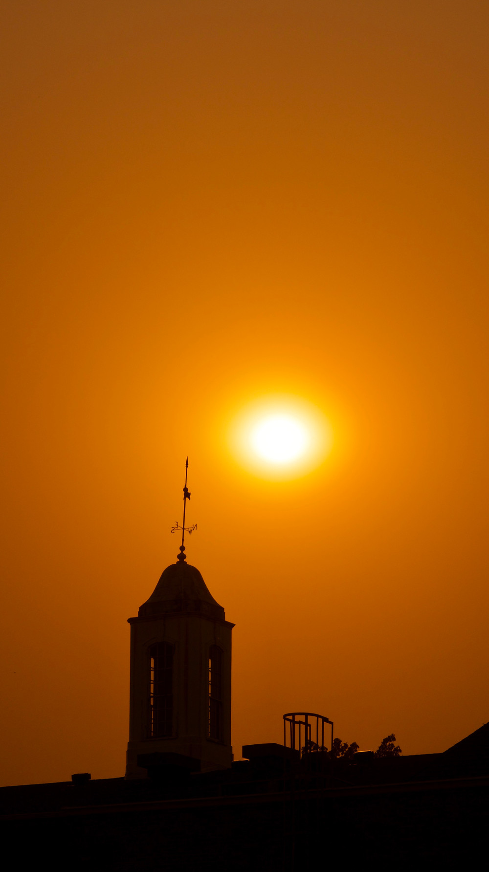Orange skies due to the nearby fires against Smullin Hall's silhouette