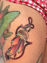 Modern traditional luck charm featuring purple-, pink-, and teal-colored crystals on top of the thigh